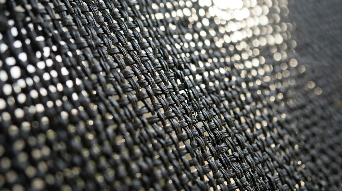Solar Screen Weave Texture | Music City Blinds A macro texture shot of a charcoal solar screen shade weave with the light behind it, shallow depth of field